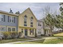A bright townhouse featuring yellow siding, gray accents, a well manicured lawn, and a private entrance at 1639 S Ivory Cir # C, Aurora, CO 80017