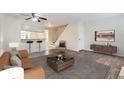 Comfortable living area with modern furnishings, a view into the kitchen, and easy access to the stairs at 1639 S Ivory Cir # C, Aurora, CO 80017