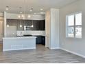 Bright, open kitchen with a large island, stainless appliances, and dark cabinetry at 17569 Cerberus Ct, Monument, CO 80132