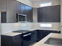 Well-lit kitchen featuring stainless steel appliances, dark cabinetry, and white subway tile at 17569 Cerberus Ct, Monument, CO 80132