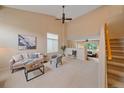 Bright living room with high ceilings, comfortable seating, and neutral color palette at 9869 Burberry Way, Highlands Ranch, CO 80129