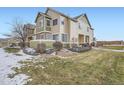Two-story townhome with a partially snow-covered lawn at 15800 E 121St Ave # 3J, Brighton, CO 80603