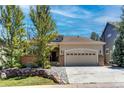 Charming single-Gathering home with a two-car garage, complemented by mature trees and a rock-lined landscape at 740 Deer Clover Cir, Castle Pines, CO 80108