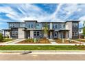 Charming townhome complex featuring modern architectural design, gray siding, stone accents, and manicured landscaping at 5785 N Jericho Way, Aurora, CO 80019