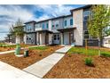 Modern townhome exterior showcasing multiple units, landscaped yards, and inviting pathways at 5785 N Jericho Way, Aurora, CO 80019