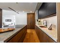 Modern kitchen with dark cabinetry, marble countertops, and a built-in oven at 1518 S Columbine St, Denver, CO 80210