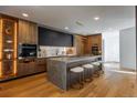 Contemporary kitchen featuring wood cabinets, black upper cabinets, marble counters, large island with seating at 1518 S Columbine St, Denver, CO 80210