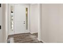 Bright foyer with wood-look floors, a white front door, and natural light streaming in at 6514 Agave Ave, Castle Rock, CO 80108