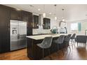Modern kitchen features stainless steel appliances, dark cabinetry, and a spacious island with seating at 1336 Sheridan Blvd # 108, Denver, CO 80214