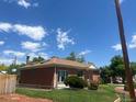 Brick home featuring side yard with grass and partial fence at 10759 Ogden St, Northglenn, CO 80233