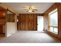 Cozy living room featuring wood paneled walls, carpet floors, and a ceiling fan at 10759 Ogden St, Northglenn, CO 80233