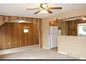 Open living room showcasing wood paneled walls, carpet floors, and arched doorway at 10759 Ogden St, Northglenn, CO 80233