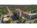 A view of the high rise condo, pool, adjacent condos, and a busy street at 4570 E Yale Ave # 1004, Denver, CO 80222