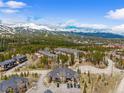 Aerial view of a mountain condo complex surrounded by lush green forests and snow-capped mountain peaks at 10 River Park Dr # A, Breckenridge, CO 80424