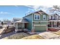 Two-story home with a covered porch, green siding, a two-car garage, and a well-manicured lawn at 9811 Gatesbury Cir, Highlands Ranch, CO 80126