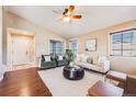 Bright living room featuring hardwood floors, neutral walls, a ceiling fan, and ample natural light at 9811 Gatesbury Cir, Highlands Ranch, CO 80126