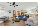 Bright living room featuring an open layout, modern ceiling fan, and stylish furnishings at 2424 S Steele St, Denver, CO 80210