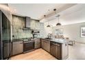 Modern kitchen features stainless steel appliances, green tile backsplash, wood floors and an open floorplan at 1950 N Logan St # 411, Denver, CO 80203