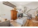 Cozy living room with a fireplace, hardwood floors, and elegant furnishings at 8872 E 47Th Ave, Denver, CO 80238