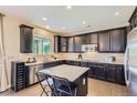Modern kitchen with dark wood cabinets, stainless steel appliances, and a center island with seating at 4545 S Monaco St # 436, Denver, CO 80237
