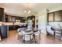 Open-concept kitchen with dark cabinetry, stainless appliances, adjoining dining area, and a built-in desk at 4545 S Monaco St # 436, Denver, CO 80237