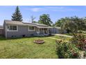Single-story home with solar panels and landscaped front yard featuring mature trees and flowers at 7350 Dale Ct, Westminster, CO 80030
