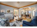 Open living room with hardwood floors and coffered ceilings leading to the dining area at 12161 S Leaning Pine Ct, Parker, CO 80134
