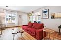 Inviting living room featuring hardwood floors, a bright window, and a stylish red sofa at 2557 S Dover St # 30, Lakewood, CO 80227