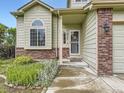 Inviting front entrance showcasing a well-kept lawn, brick accents, and the house number at 4267 Ashcroft Ave, Castle Rock, CO 80104