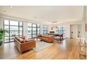 Spacious living room with expansive windows offering city views and hardwood floors at 1590 Little Raven St # 702, Denver, CO 80202