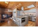 Modern kitchen featuring a brick fireplace, custom cabinets, and an island with seating, perfect for entertaining at 1400 E Bates Ave, Englewood, CO 80113