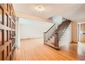 Bright foyer featuring hardwood floors, a staircase with wooden railings, and natural light at 7700 E Oxford Ave, Denver, CO 80237