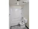 Bathroom view with a white shower and tub combination, a toilet, and a towel rack at 7665 E Eastman Ave # 104A, Denver, CO 80231