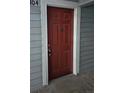 A close-up of the front door with a red door and a white trim, and the number 104 above it at 7665 E Eastman Ave # 104A, Denver, CO 80231