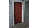 A close-up view of a red painted front door with white trim at 7665 E Eastman Ave # 104A, Denver, CO 80231