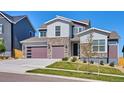 Charming two-story home with modern garage doors, stone accents, and a well-maintained lawn at 14337 Shasta Daisy Pt, Parker, CO 80134