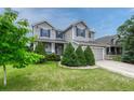 Well-maintained two-story home with gray siding, blue shutters, and a neatly landscaped front lawn at 2171 E 99Th Pl, Thornton, CO 80229