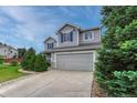 Attractive gray two-story home with blue shutters, showcasing a tidy front yard and attached garage at 2171 E 99Th Pl, Thornton, CO 80229