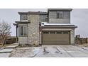 Two-story home featuring stone accents and an attached two car garage with well-maintained landscaping at 17265 E 110Th Ct, Commerce City, CO 80022