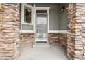 Stone pillars frame the front door entrance with a glass insert at 5008 S Nepal St, Centennial, CO 80015