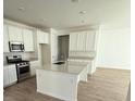 Well-lit kitchen offers ample counter space, stainless steel appliances, white cabinetry, and a spacious island at 9041 Redfield Ln, Parker, CO 80134
