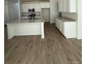 Bright kitchen features white cabinets, a large island, modern stainless steel appliances, and hardwood floors at 9041 Redfield Ln, Parker, CO 80134