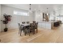 Bright dining room with wood paneled wall, modern chandelier, and an open view to the kitchen at 1953 W 47Th Ave, Denver, CO 80211