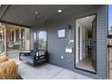 Charming covered front porch featuring a porch swing, sleek siding and contemporary house number at 3409 Navajo St, Denver, CO 80211