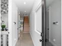 Bright hallway with modern fixtures, leading to a staircase and featuring stylish, geometric-tiled half-bath at 3409 Navajo St, Denver, CO 80211