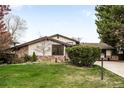 Charming home with stone accents, manicured lawn, and mature landscaping at 6389 S Monaco Ct, Centennial, CO 80111