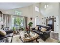 Bright living room with vaulted ceilings, large windows, and comfortable leather seating at 4205 E 106Th Pl, Thornton, CO 80233