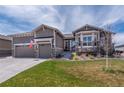 Charming exterior showcases stone accents, three-car garage, well-maintained lawn, and beautifully landscaped front yard at 8463 S Quemoy Ct, Aurora, CO 80016