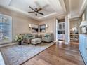 Elegant sitting room featuring hardwood floors, stylish chairs, and a convenient bar area at 8463 S Quemoy Ct, Aurora, CO 80016