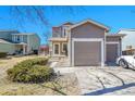 Charming two-story home featuring a spacious two car garage with a well-maintained lawn and inviting front entrance at 853 Mockingbird St, Brighton, CO 80601